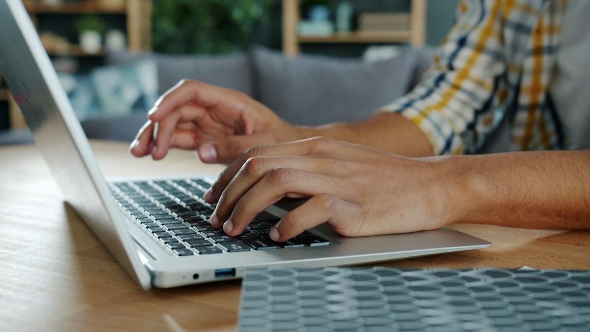 Hands using a laptop to review online shopping records, illustrative stock photograph